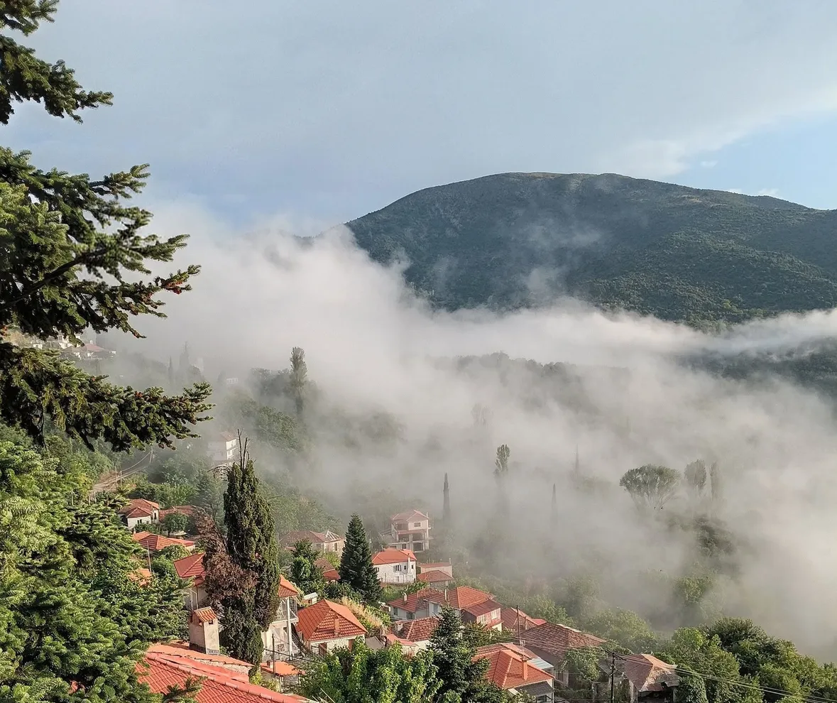 Η Περίστα μέσα στην ομίχλη, με τα κεραμιδί σπίτια στην πλαγιά